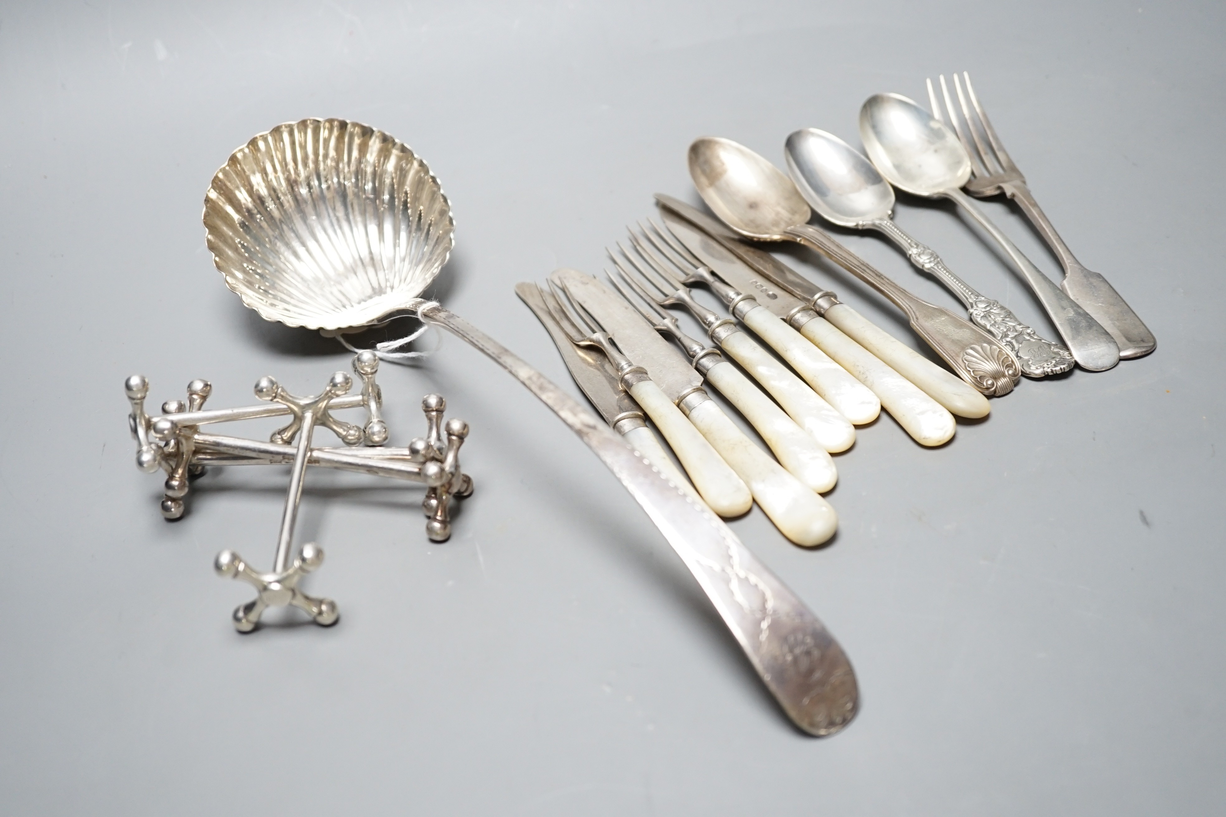 An 18th century silver Old English pattern soup ladle, marks rubbed,(a.f.), two pairs of silver knife rests including Mappin & Webb, Sheffield, 1915 and twelve other items of flatware.